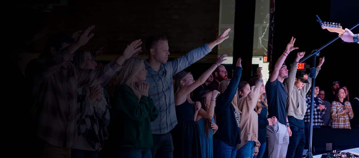 A congregation worshiping with hands raised