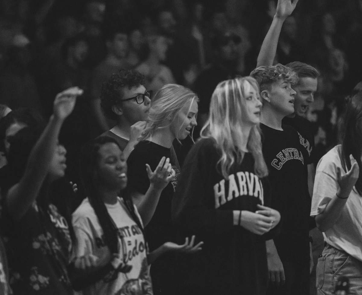 A crowd worshiping together, in black and white